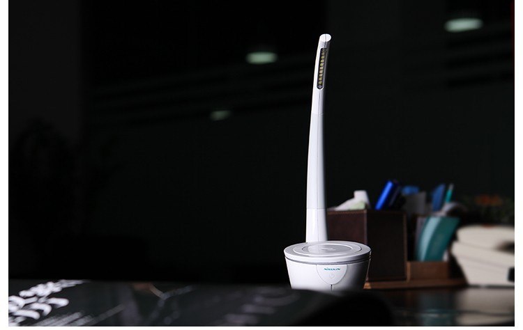 White cleaning brush with long handle on a dark surface